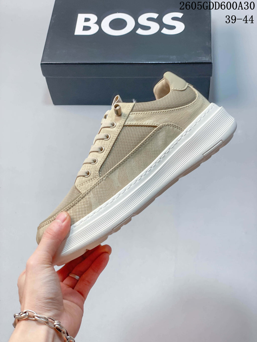 Side profile of a beige BOSS sneaker with textured panels and a white sole