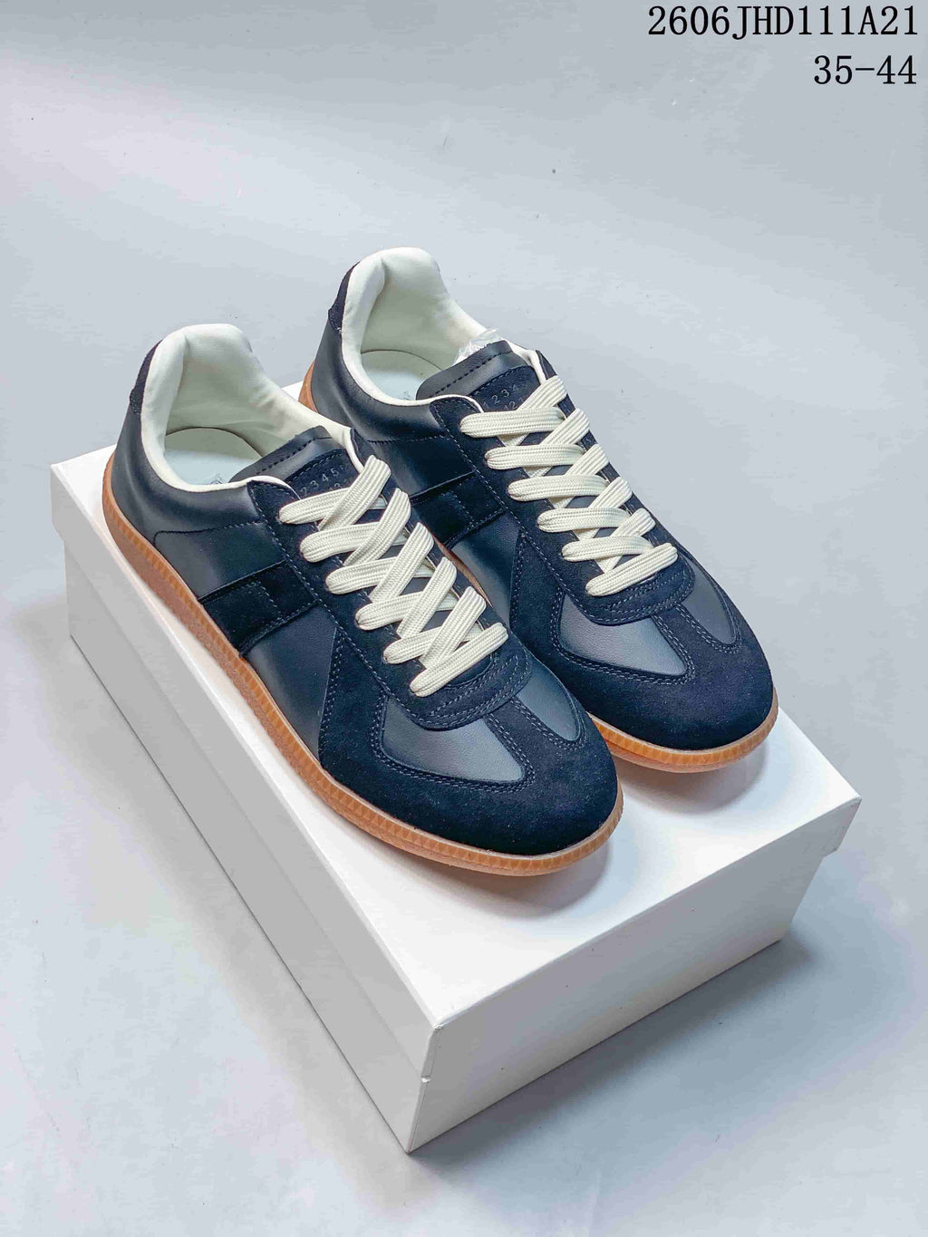 Pair of navy low-top Replica sneakers with cream laces and gum-colored soles