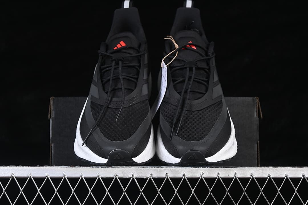Front view of a pair of black shoes with white midsoles and red tongue logos.