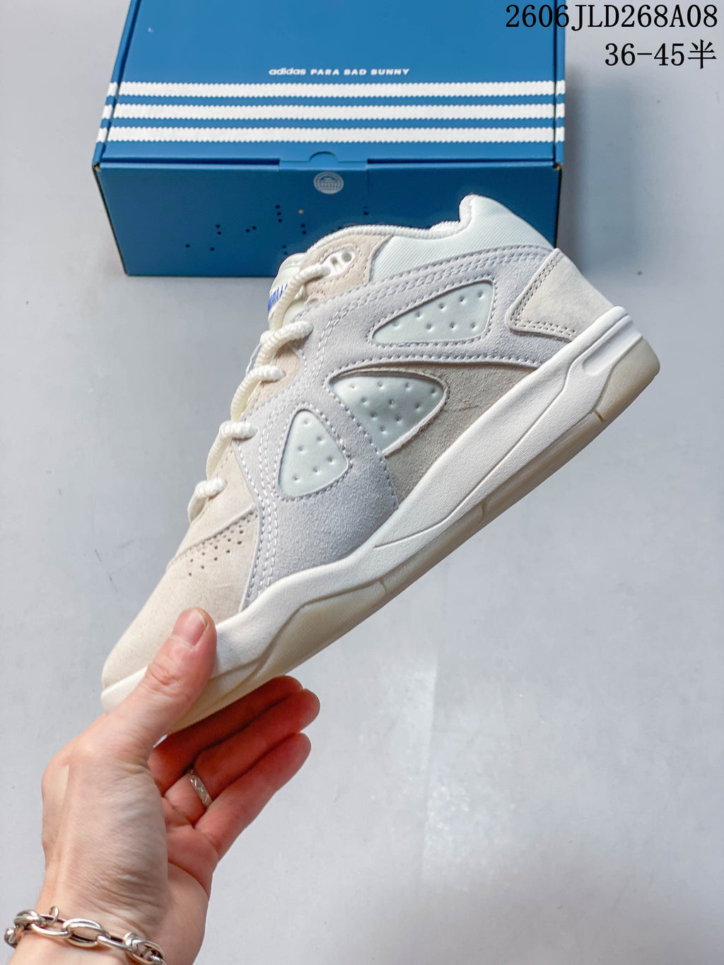 Side view of the cream sneaker with layered panels and perforated details
