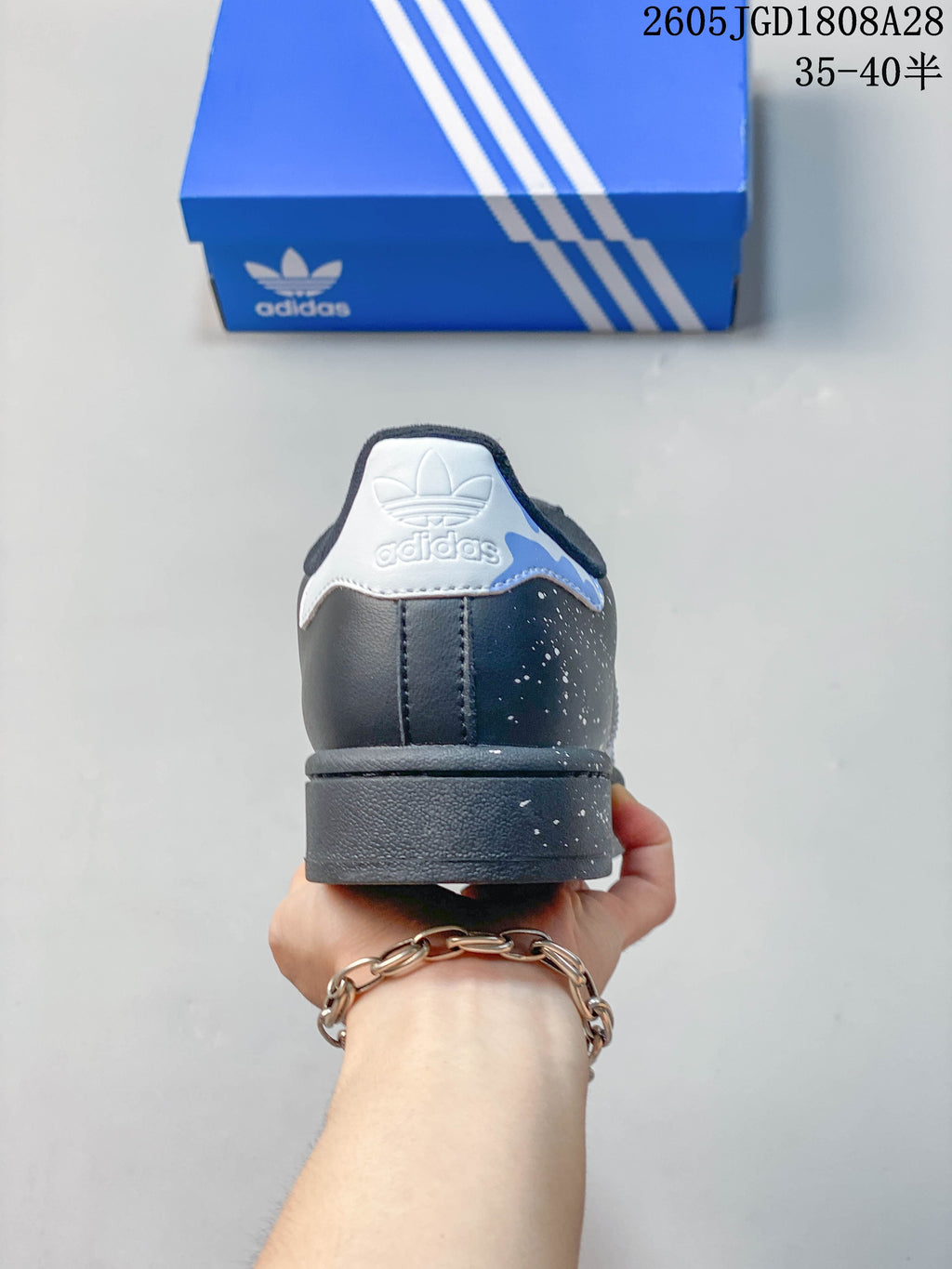 Rear view of the sneaker with a white heel tab and speckled charcoal finish