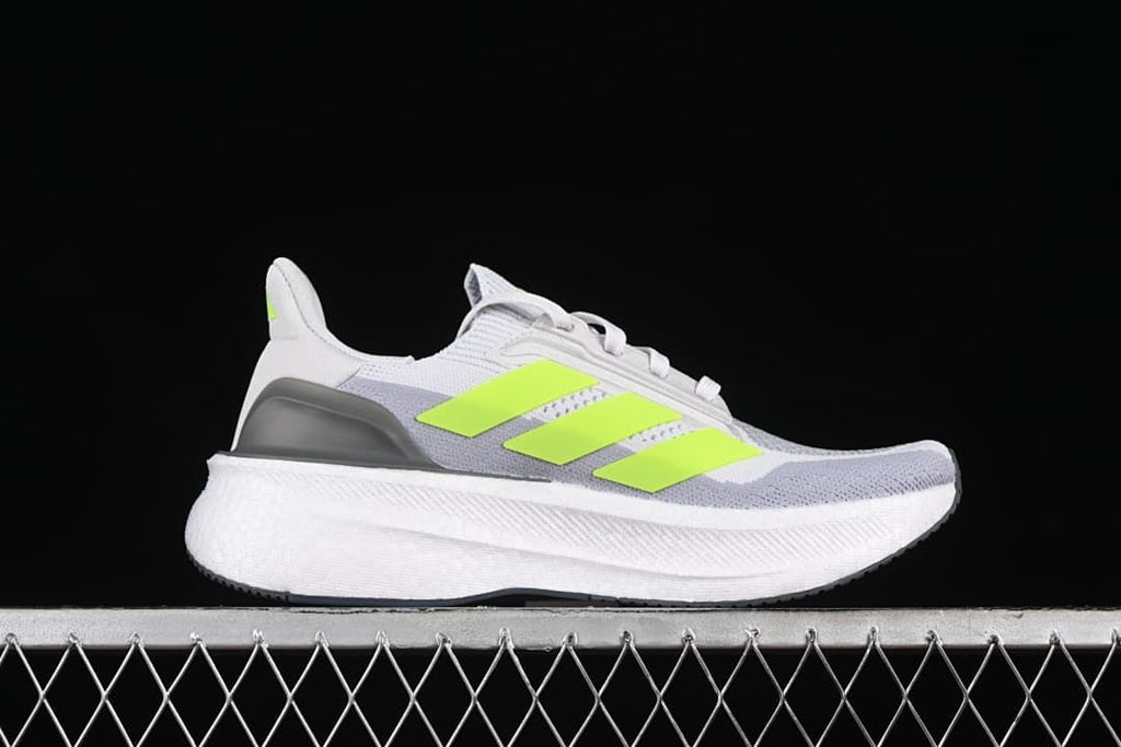 Side profile of a gray and white Ultraboost 5X shoe with lime stripes.