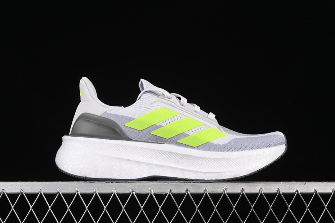 Side profile of a gray and white Ultraboost 5X shoe with lime stripes.