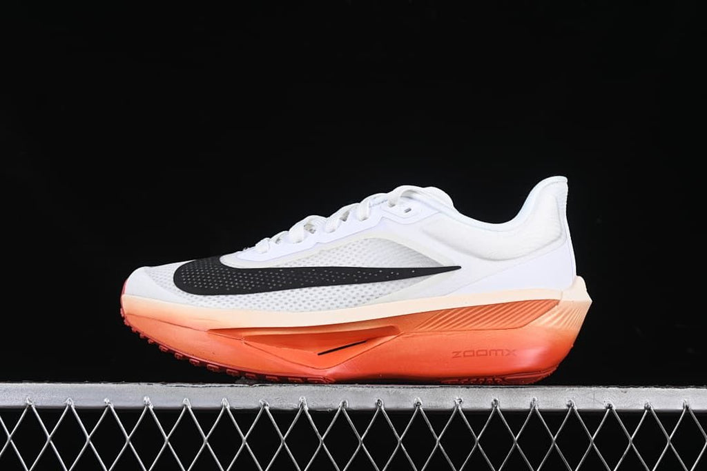 Side view of the white shoe with black Swoosh and coral-orange sole