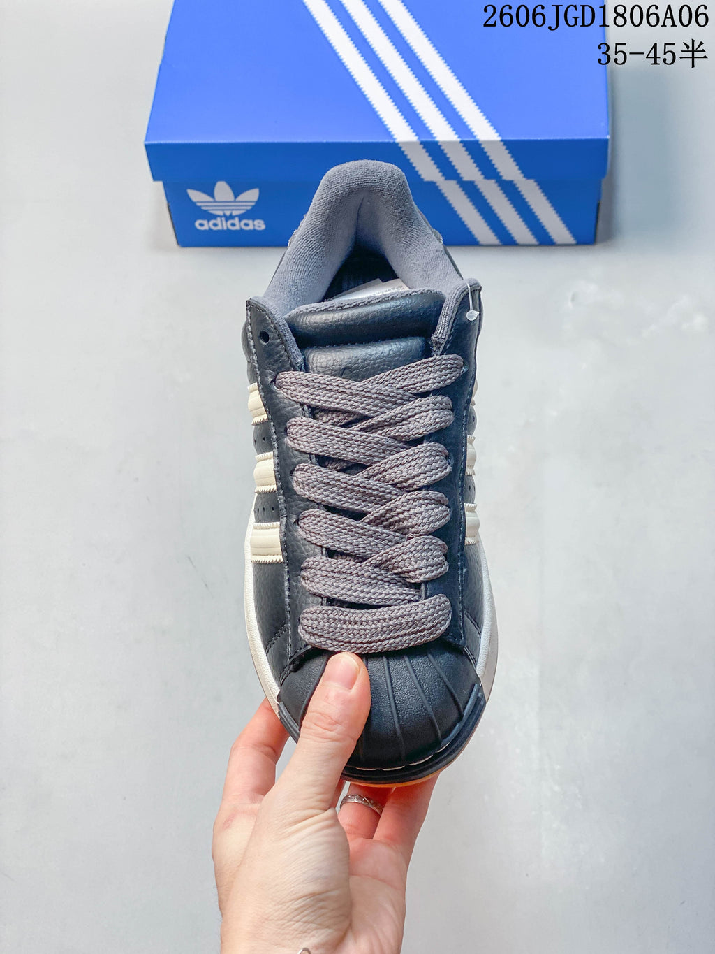 Front view of the sneaker showing grey laces and the ribbed shell toe.