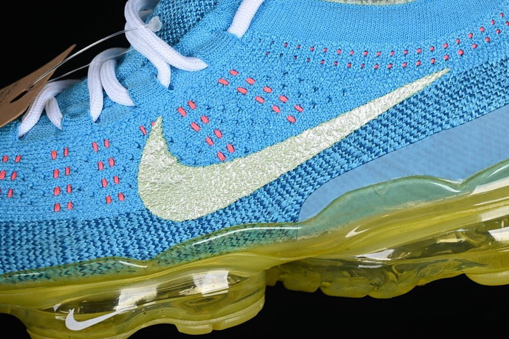 Detail of the blue knit upper, coral accents, pale Swoosh and sole.