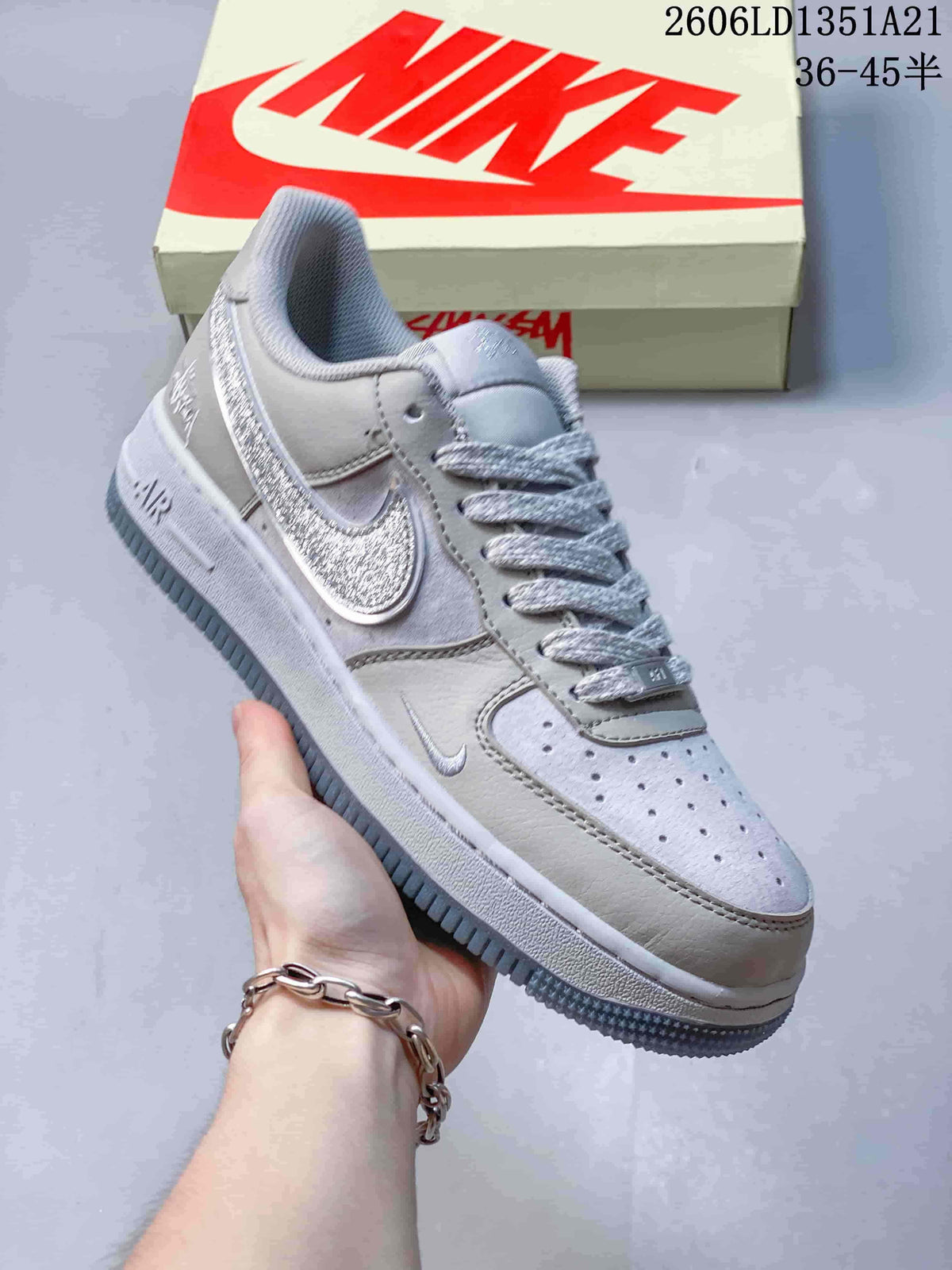 Angled view of the light gray Nike Air Force 1 with textured silver-toned details