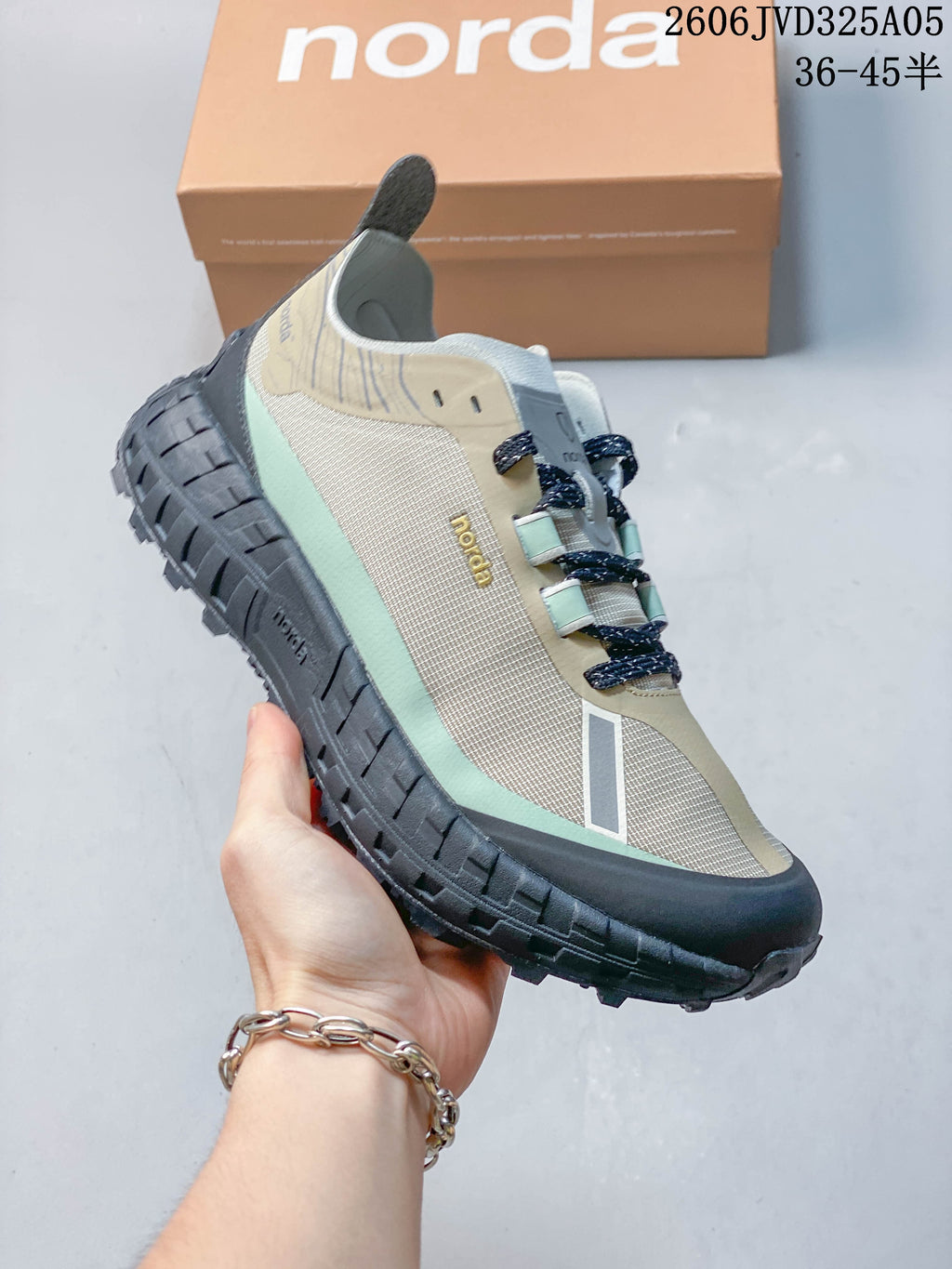 Angled side view of the beige and mint Norda 001 shoe.