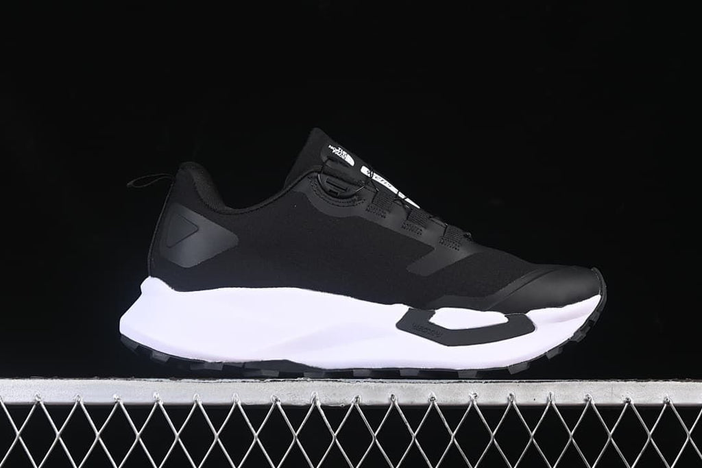 Side view of the shoe with its black upper and white midsole.