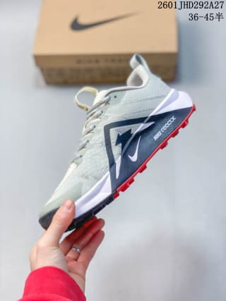 Side view showing the layered white midsole, dark side branding, red outsole lugs, and heel pull tab.