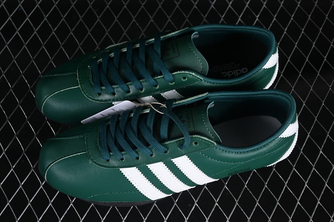 Pair of green low-top sneakers with white stripes and dark laces.