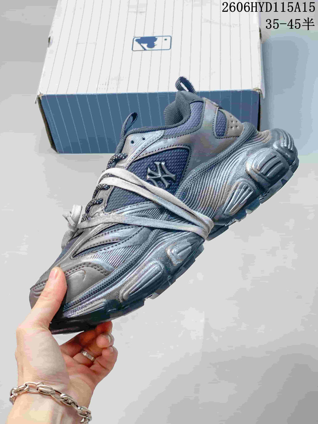 Side view of the silver-gray MLB sneaker with layered panels and side emblem
