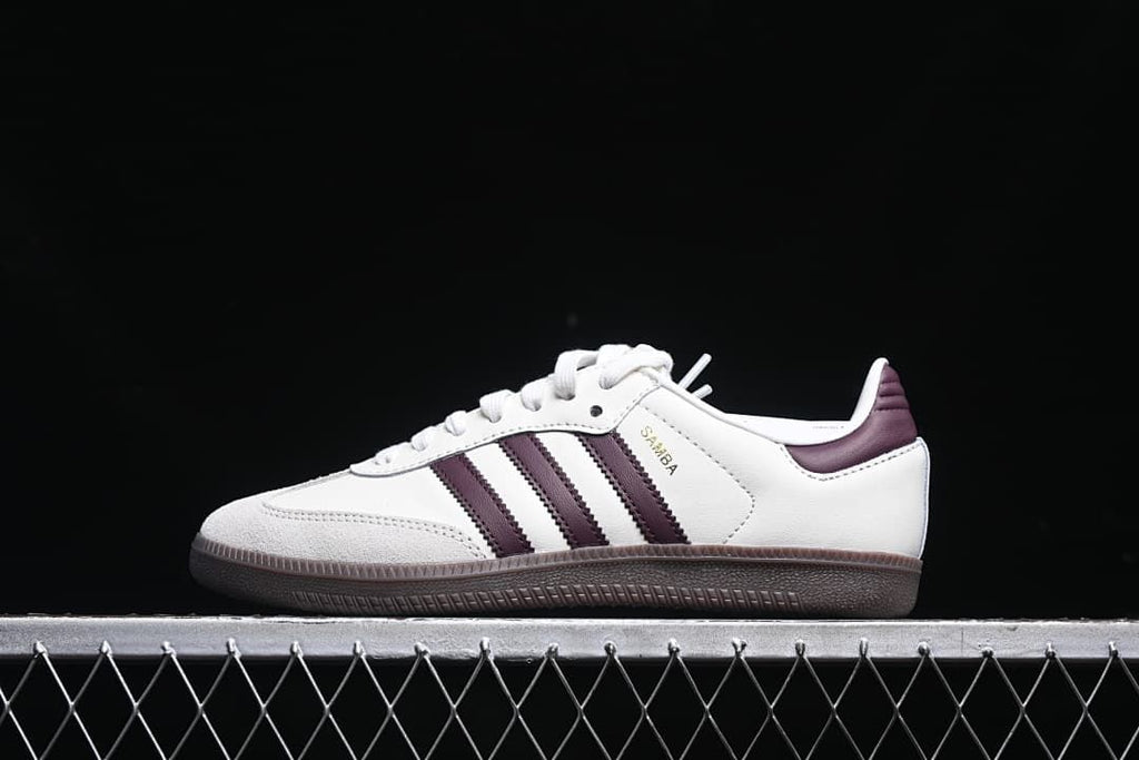 Side view of white adidas Samba OG EMMI sneakers with burgundy stripes and dark outsole