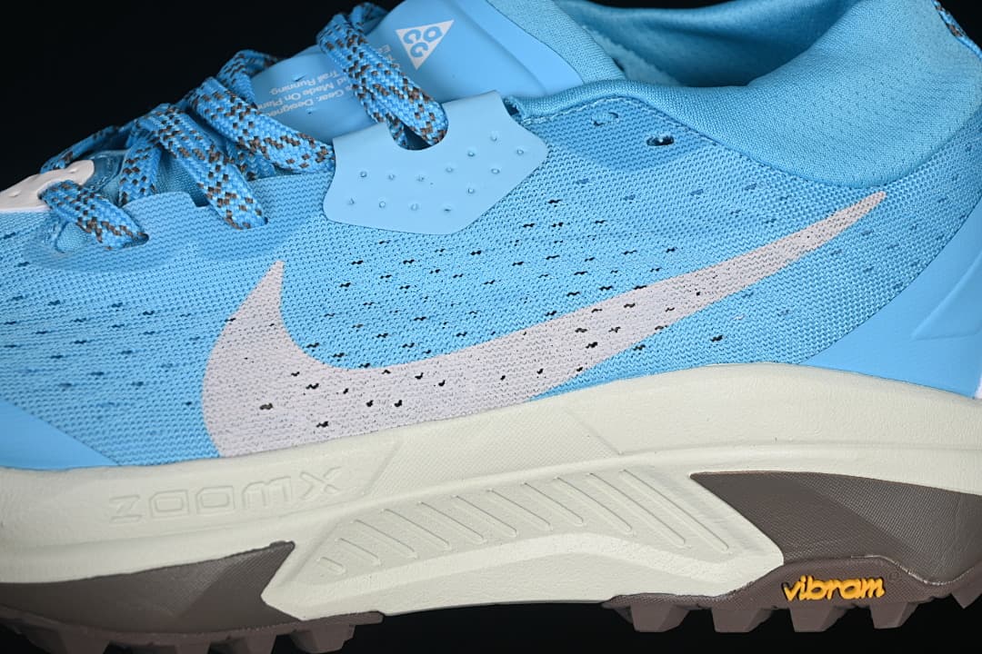 Close-up of the blue upper, Swoosh, midsole and lugged outsole.