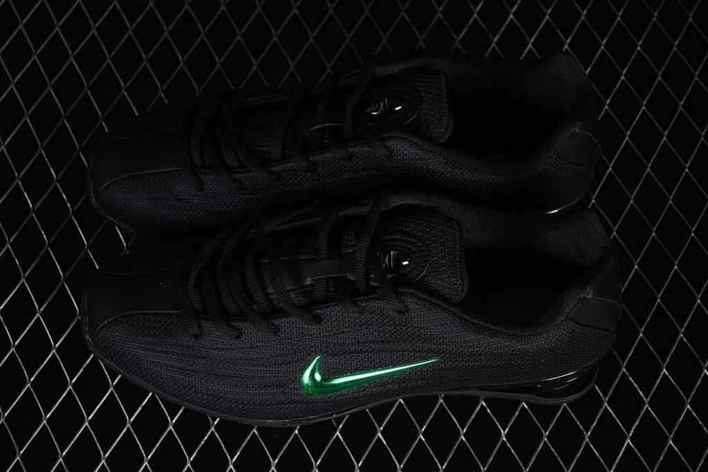 Pair of black Nike Shox Z sneakers with green Swooshes.