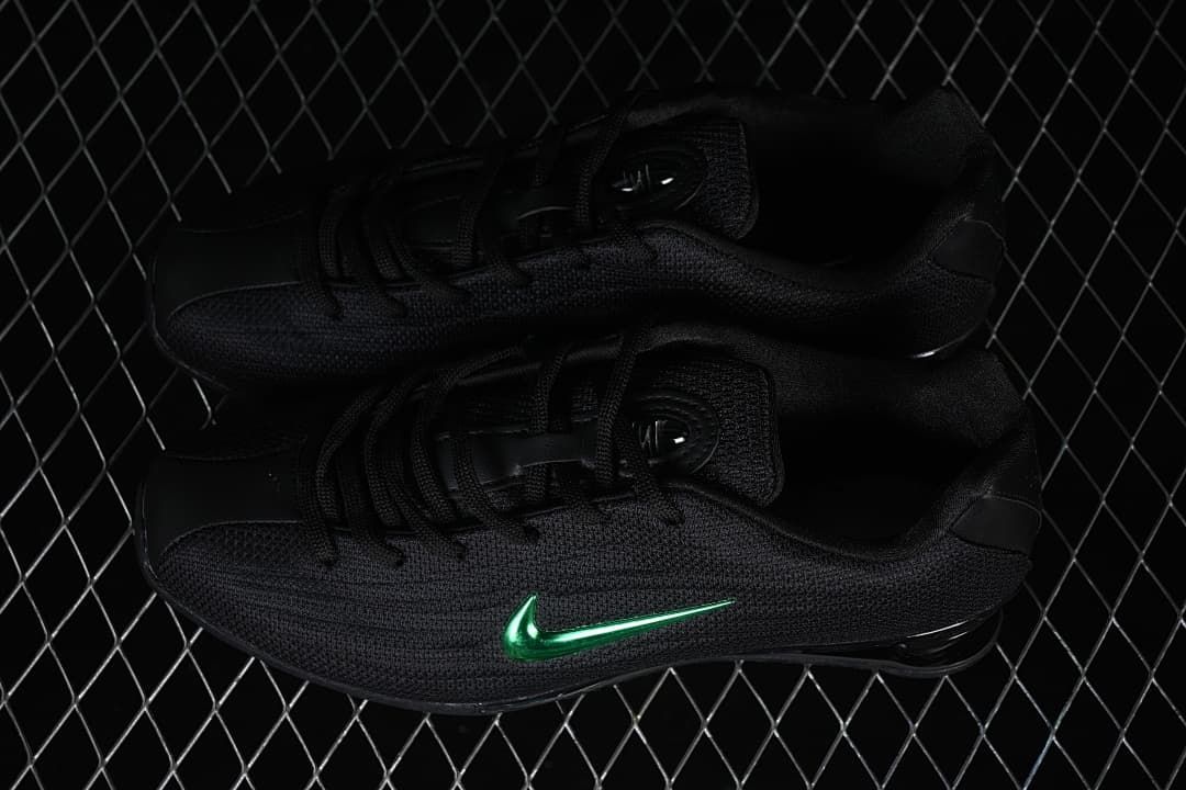 Pair of black Nike Shox Z sneakers with green Swooshes.