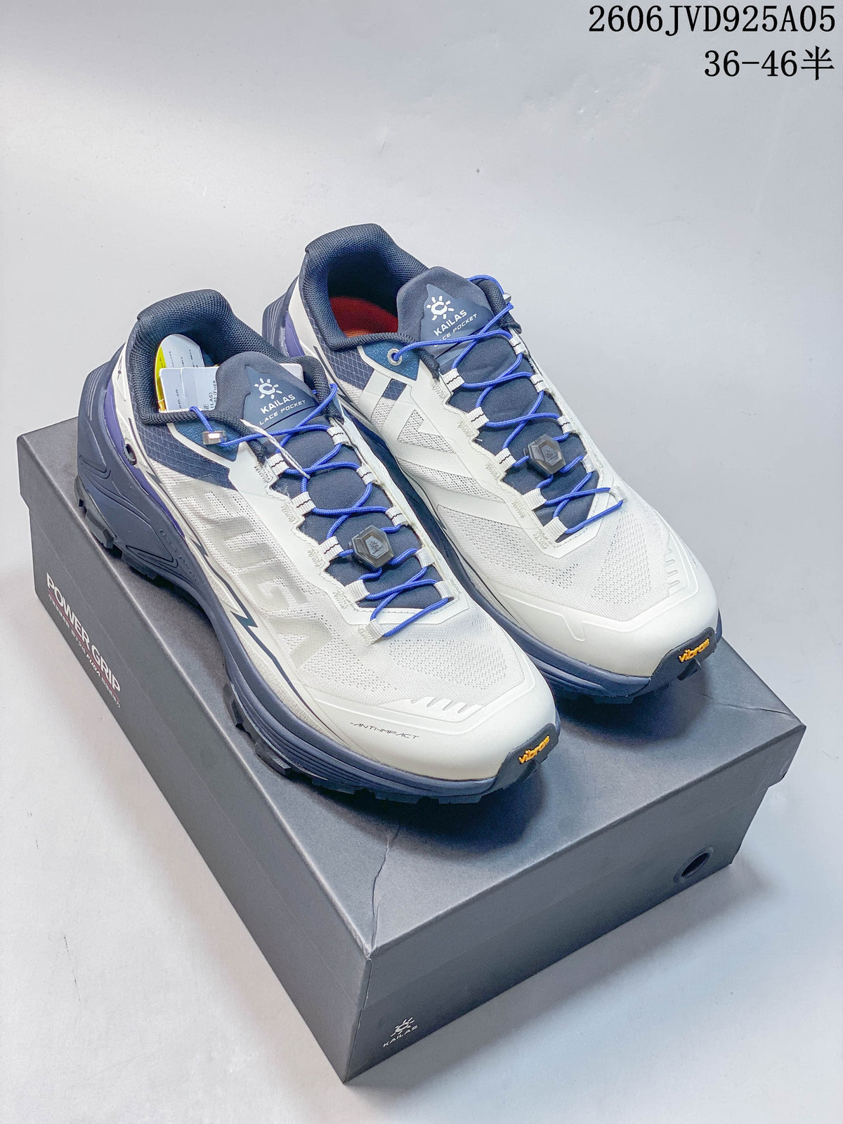 Pair of white, blue, and gray Kailas FUGA EX3 BOA hiking shoes displayed on a box.