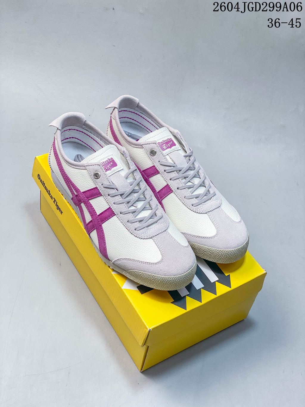 White Onitsuka Tiger sneakers with magenta stripes and light gray overlays.