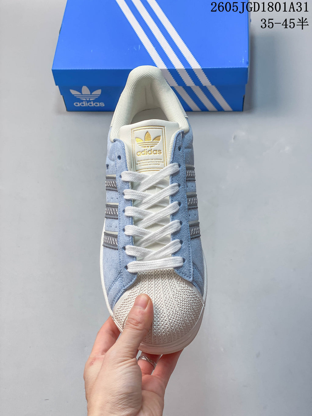 Top view of a light blue Campus 00s sneaker with white laces and a textured cream shell toe.