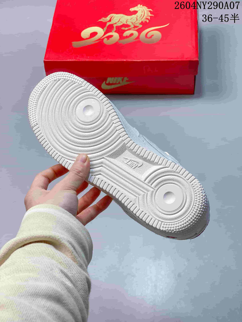 View of the white textured outsole and red horse-themed box.
