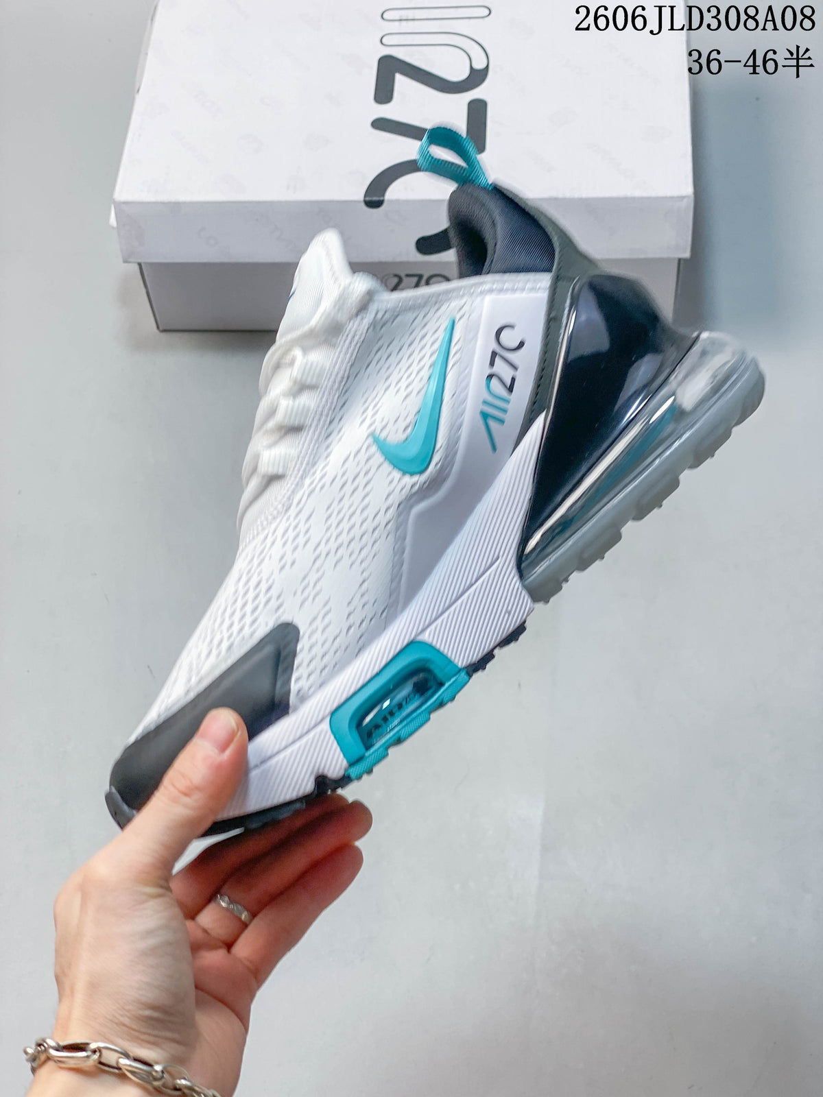 Side view of a white Nike Air Max 270 sneaker with turquoise accents and visible heel unit
