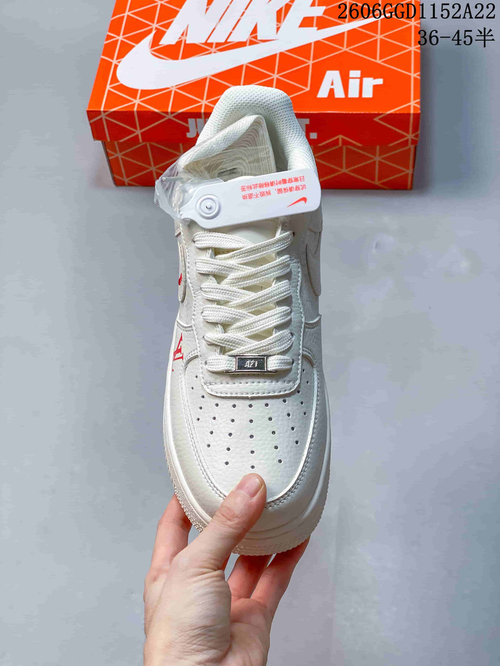 Top view of the white sneaker showing perforated toe and metal lace tag