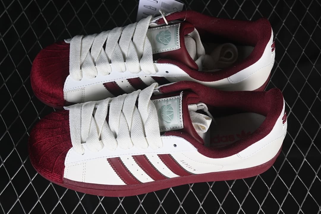 Pair of white and burgundy Superstar II sneakers viewed from above.