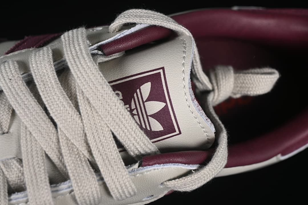 Close-up of the tongue logo and cream-colored laces.