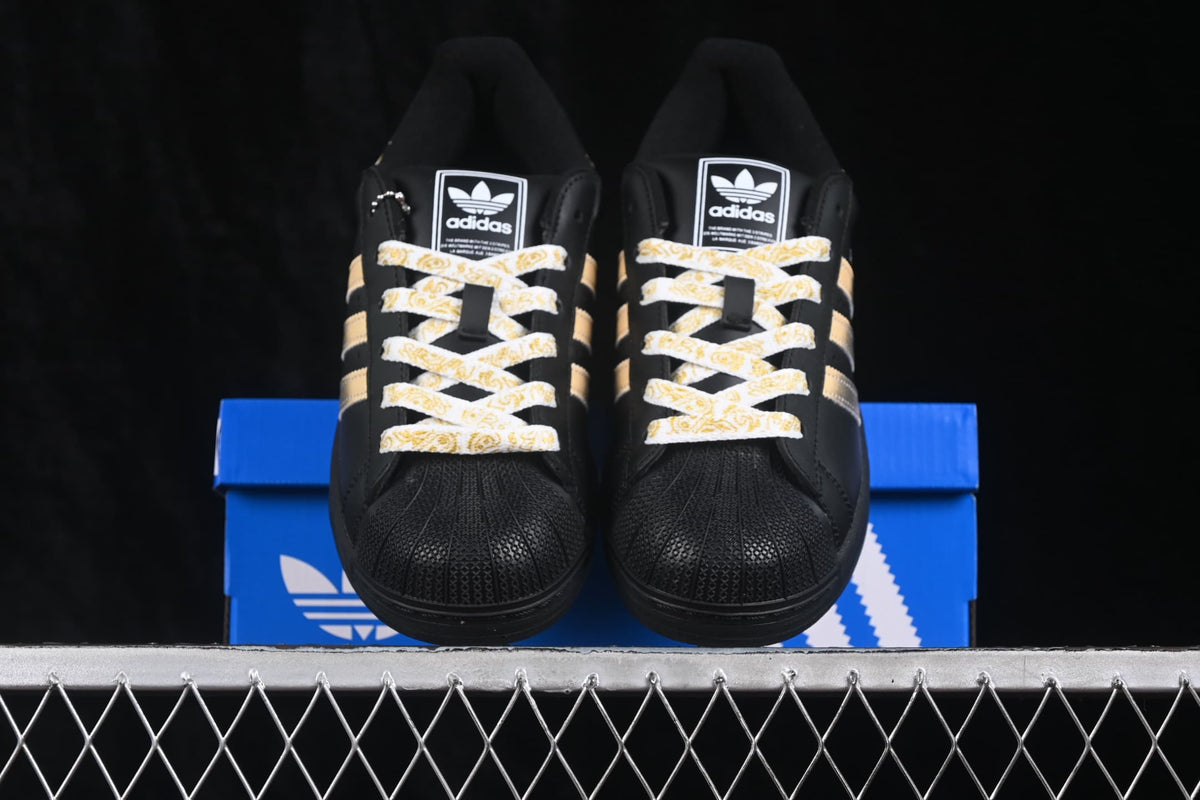 Front view of the pair showing patterned laces, branded tongues, and textured shell toes.