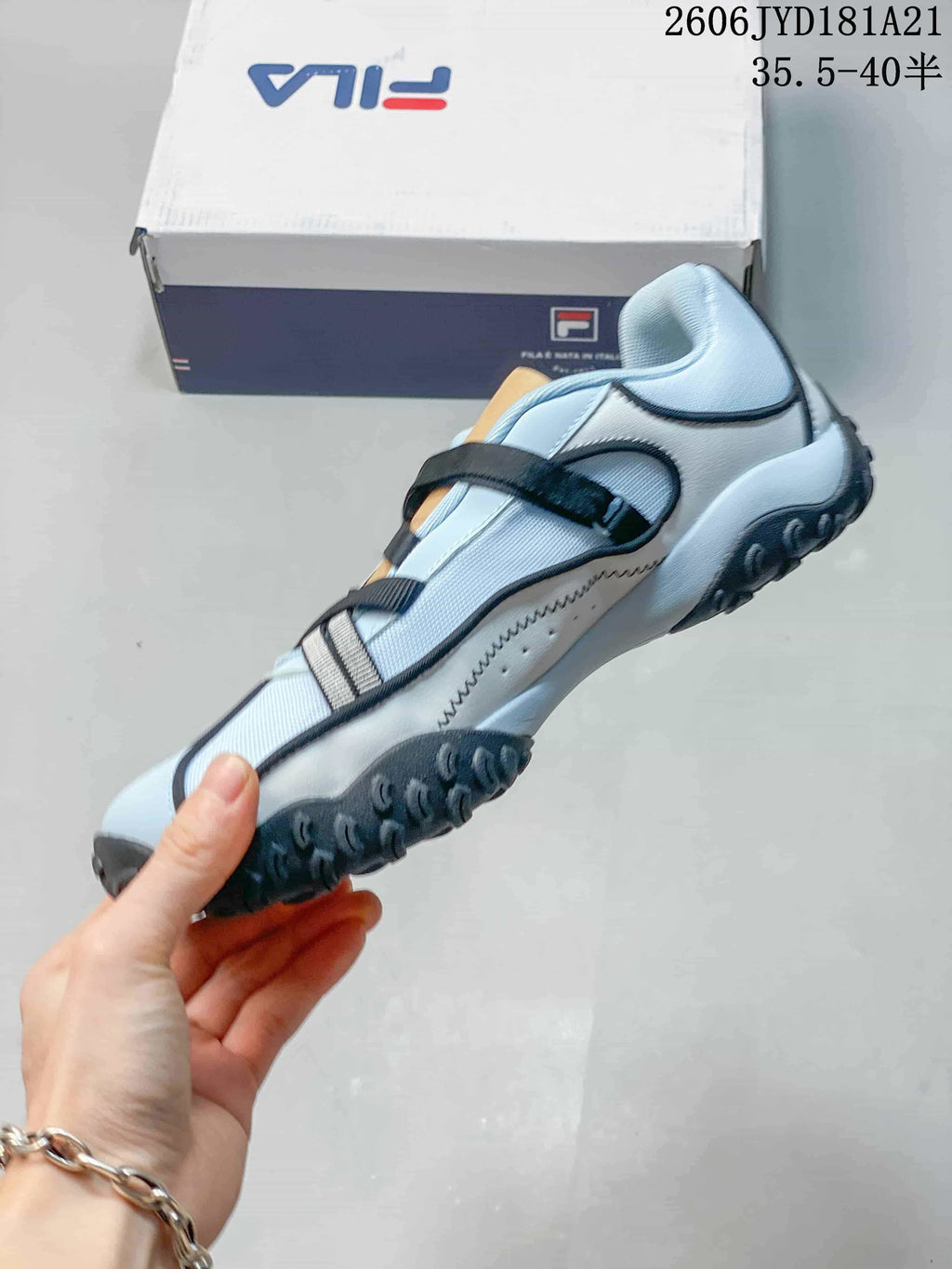 Side view of the sandal showing its crossing straps and textured outsole.