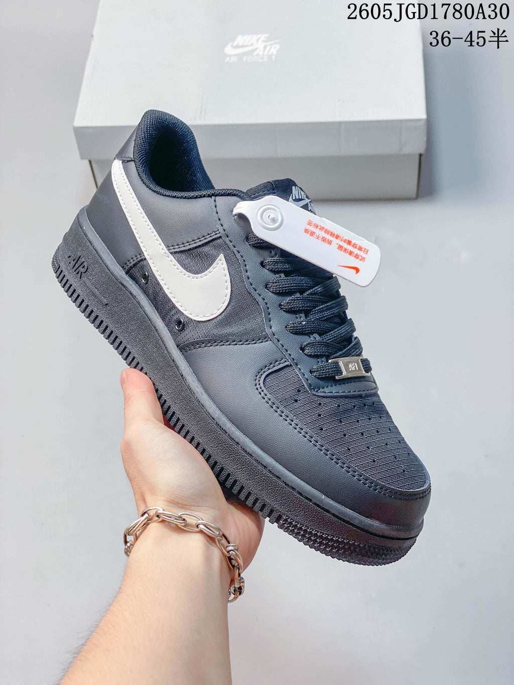 Angled view of a dark gray Nike Air Force 1 Low sneaker with a light-colored Swoosh and lace-up closure.