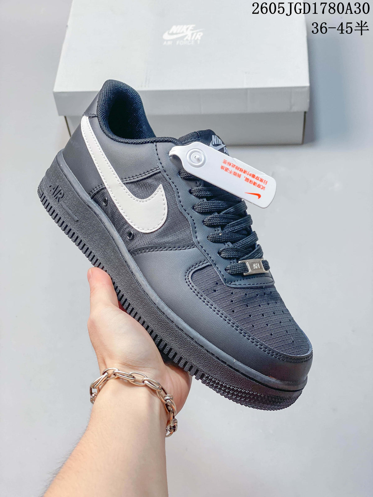 Angled view of a dark gray Nike Air Force 1 Low sneaker with a light-colored Swoosh and lace-up closure.