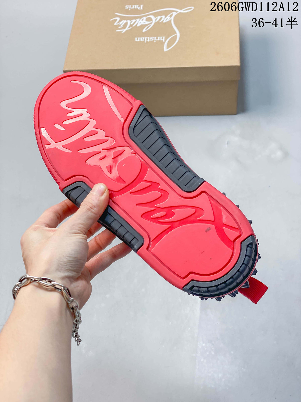 Red outsole of a black sneaker with dark tread sections