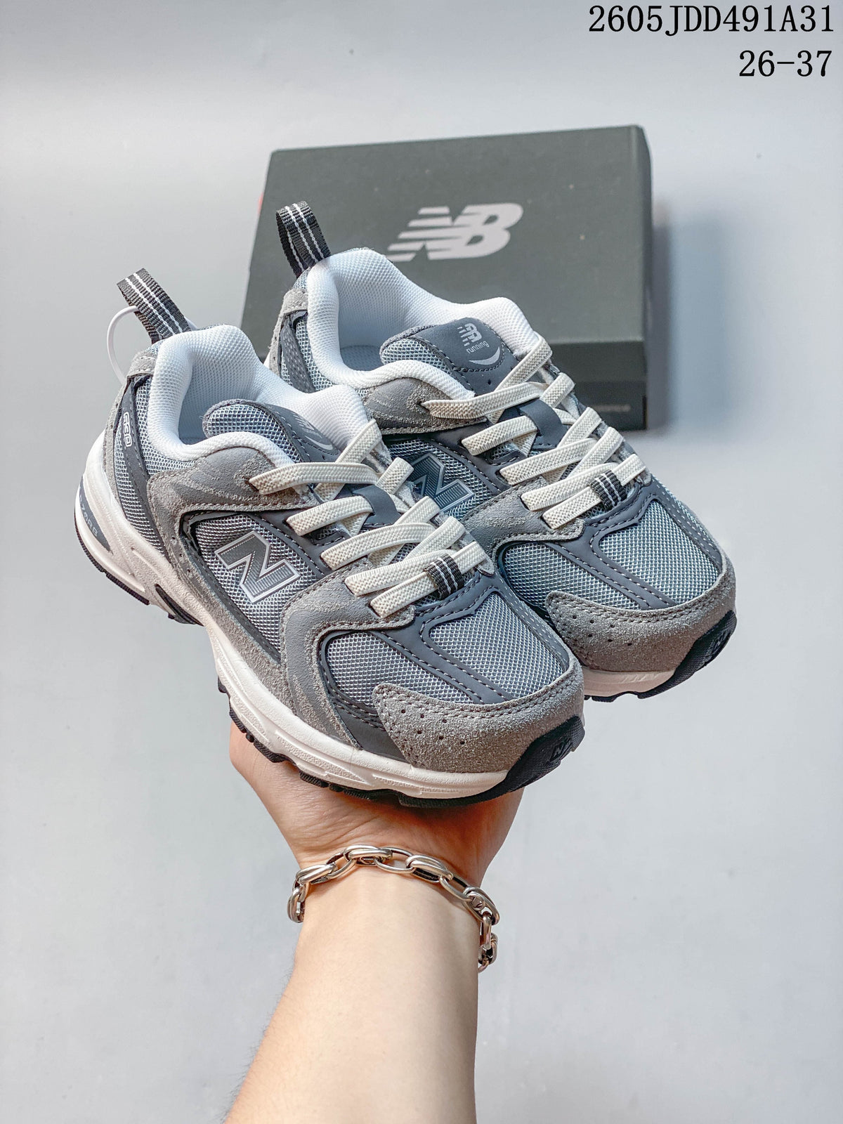 Pair of gray New Balance 530 kids' sneakers shown from the front and side