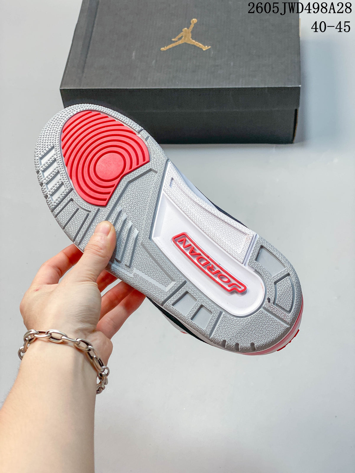 Outsole view of a Jordan sneaker with gray tread and a red circular traction area