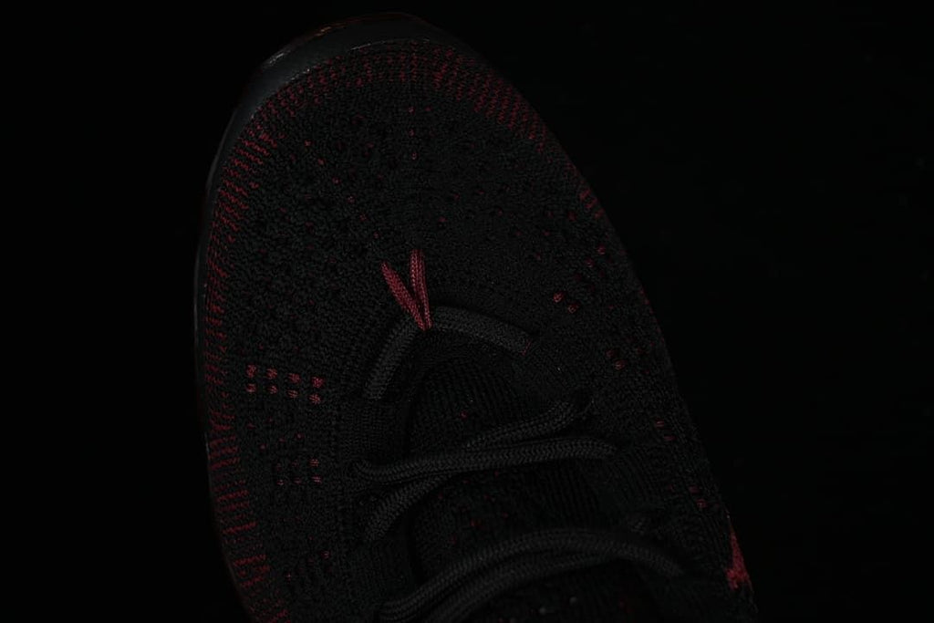 Top view of the black knit toe and lace area with dark red detailing