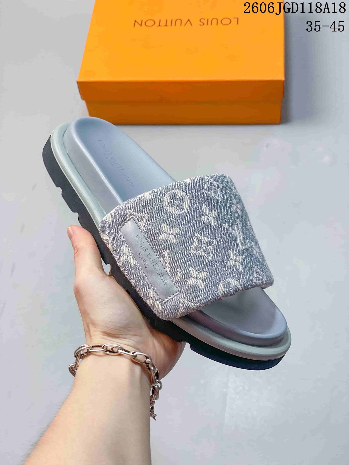 Angled close view of a gray patterned slide sandal and its wide strap