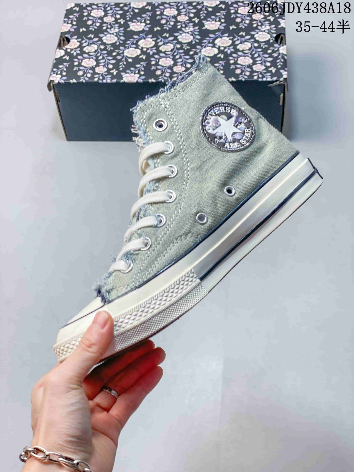 Side view of a washed denim high-top sneaker with frayed edges and white sole