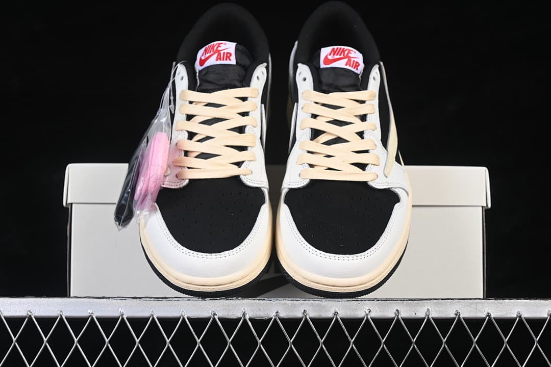 Front view of the pair with cream laces, black toe panels, and white overlays.