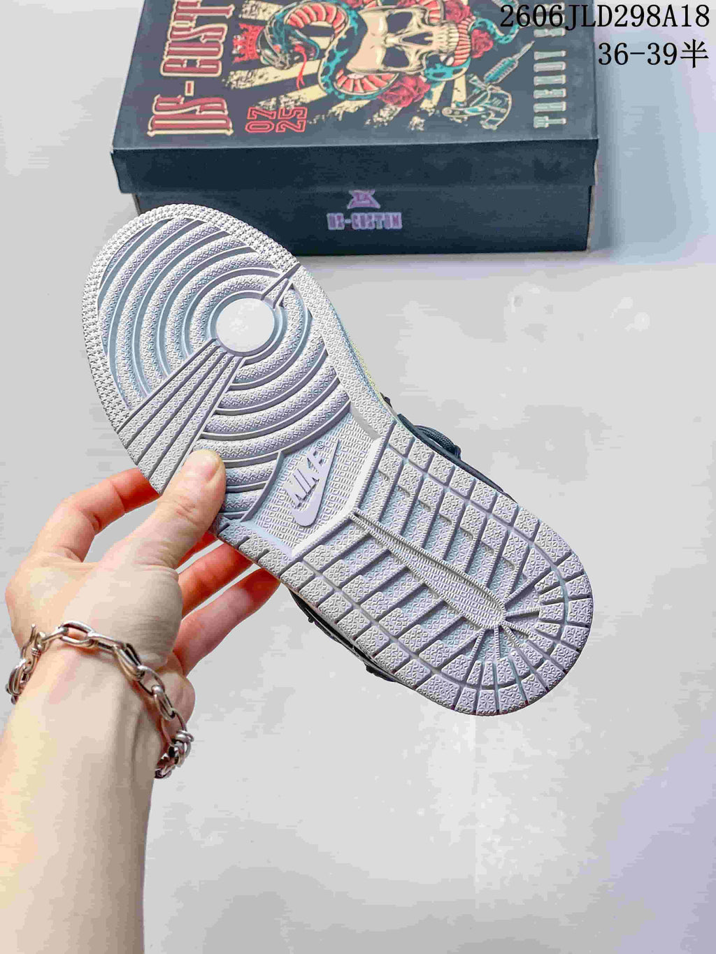 Close-up of the patterned outsole on a gray and white Air Jordan 1 Low sneaker.