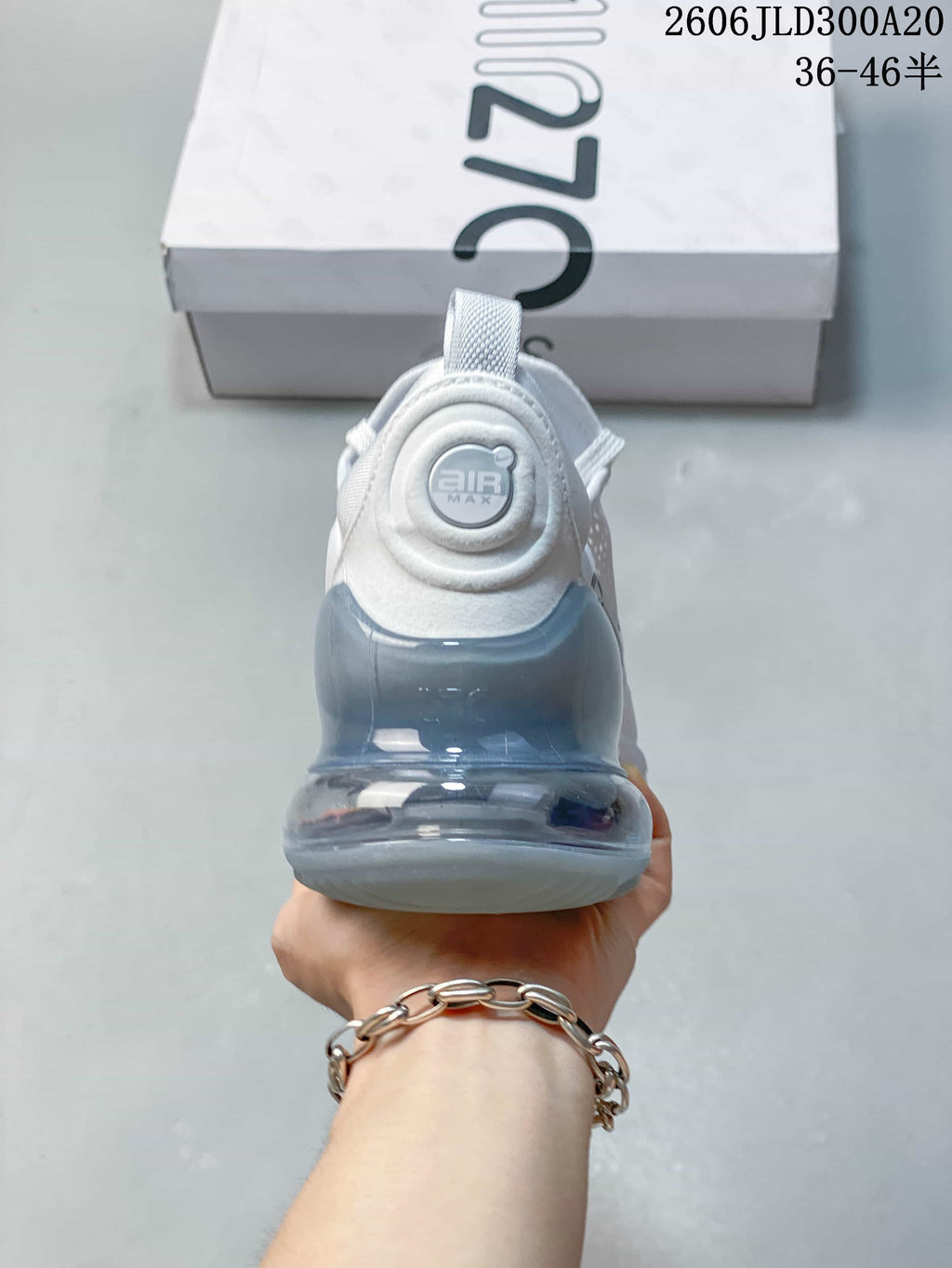 Rear view of a white Air Max 270 sneaker with a light blue-gray heel unit