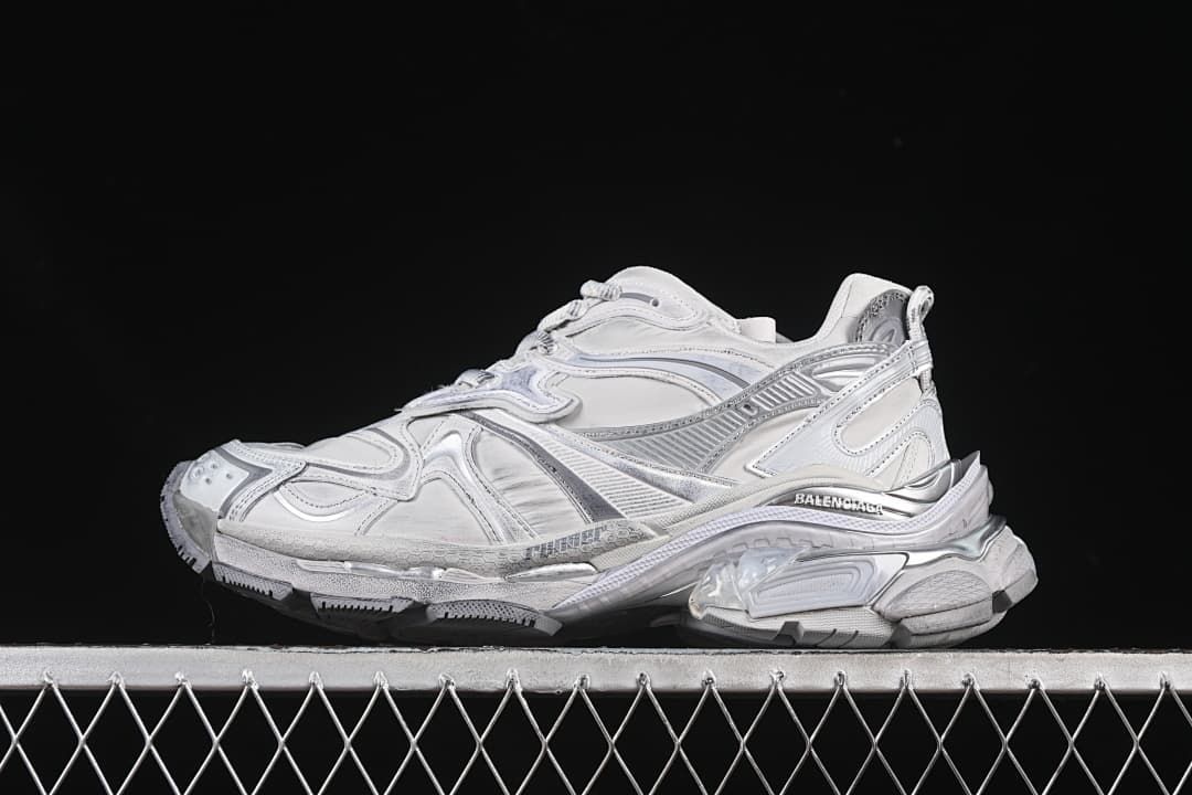 Side view of the grey and silver sneaker against a dark background.