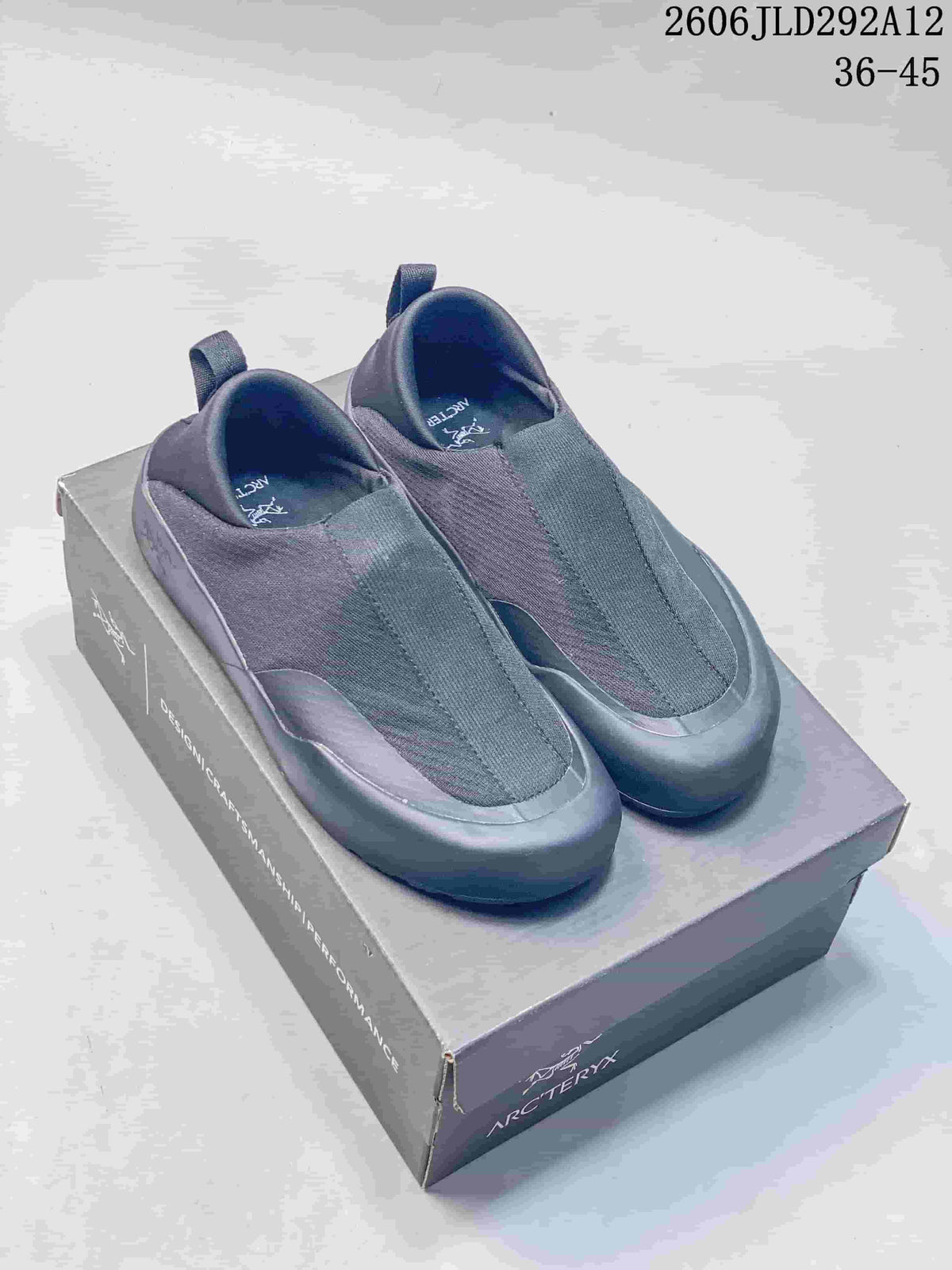 Pair of gray Arc'teryx Kragg slip-on shoes shown on a shoebox