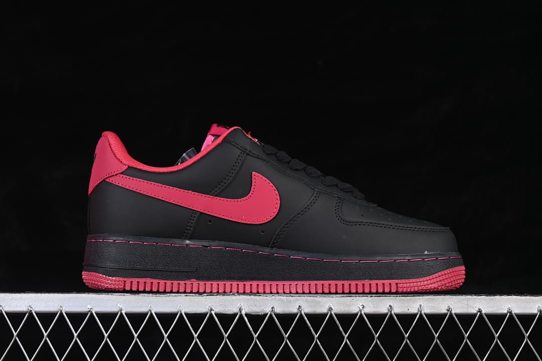 Side profile of a black low-top sneaker with red accents