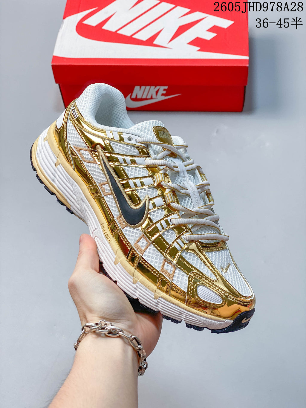 Angled side view of the white and gold-tone Nike Initiator shoe
