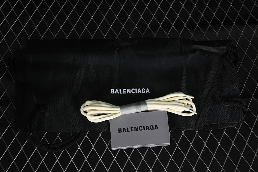 Black branded shoe bag, spare laces and booklet shown with the sneakers