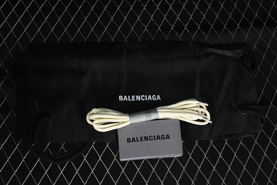 Black branded shoe bag, spare laces and booklet shown with the sneakers