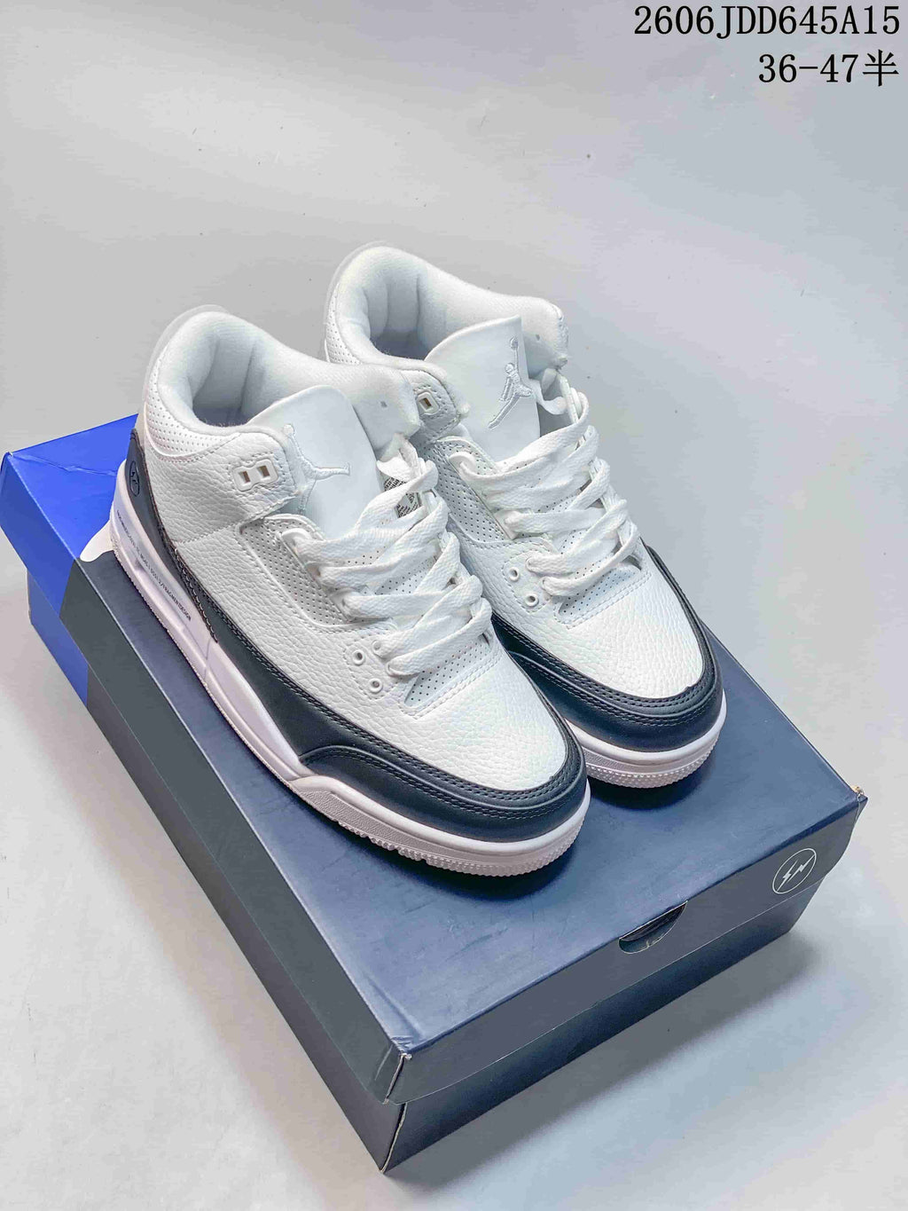 Pair of white and dark-trim Air Jordan 3 Retro sneakers on a shoebox