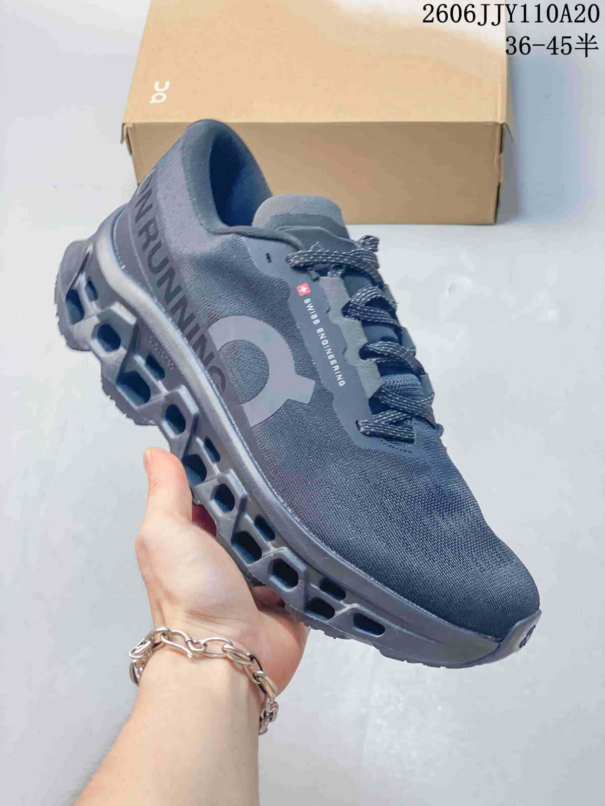 Angled side view of a gray On running shoe showing its branding and outsole.