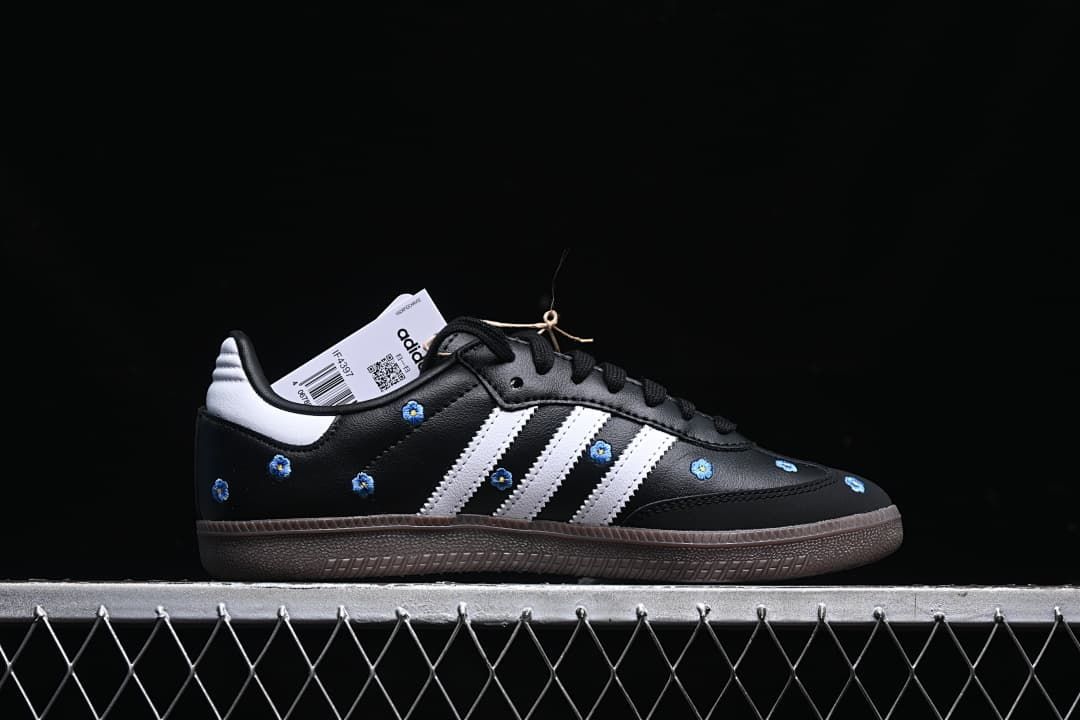 Side profile of a black Samba OG shoe with white stripes and blue floral embroidery